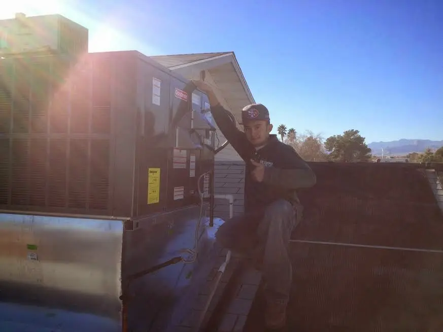 HVAC technician performing AC Tune-Up on a rooftop unit in Pismo Beach